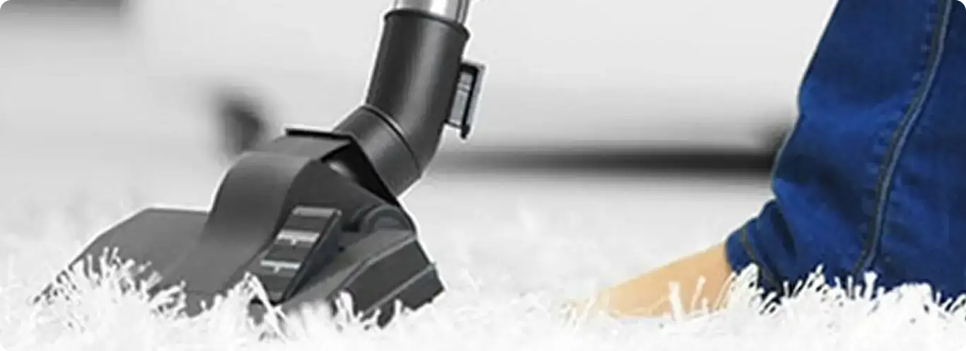 Close-up of a professional vacuuming a white carpet in Heiskell.